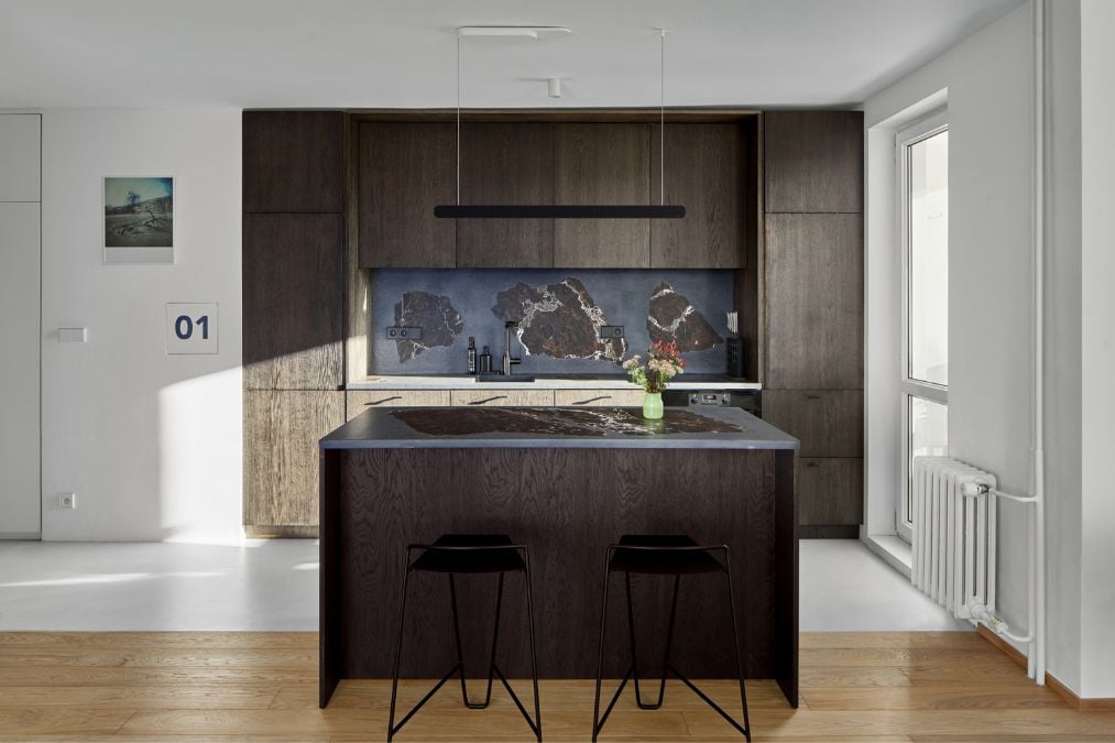 This is a detailed shot of the kitchen section, highlighting the elegant style achieved through the use of dark wood-colored cabinets and a center island.