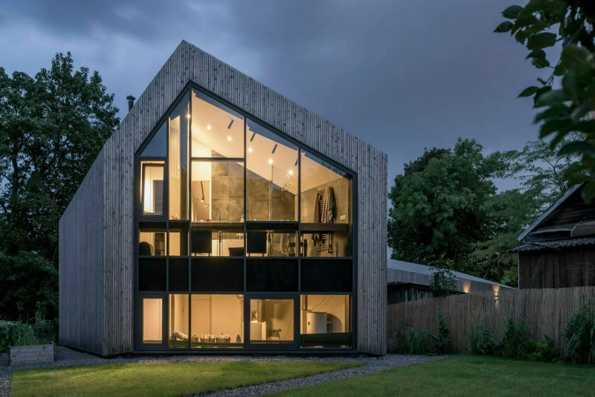 The home's interior is bathed with warm lights at night.