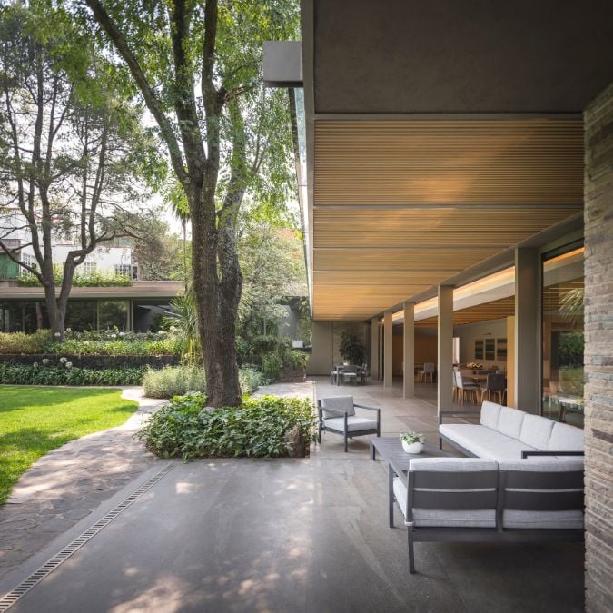 An exterior shot that showcases an outdoor living area enveloped by lush vegetation.