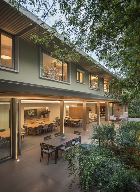 This is an outdoor patio area complete with a table and chairs situated beneath the shelter of a tree. 