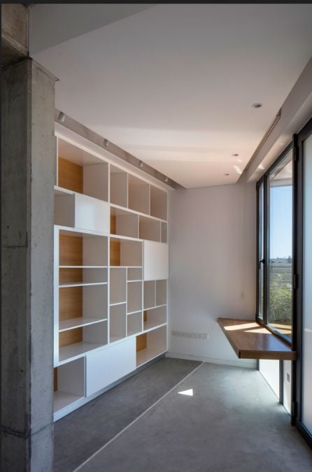 This interior shot focuses on a corner section of the room where multiple wall-mounted shelves are featured as additional storage.