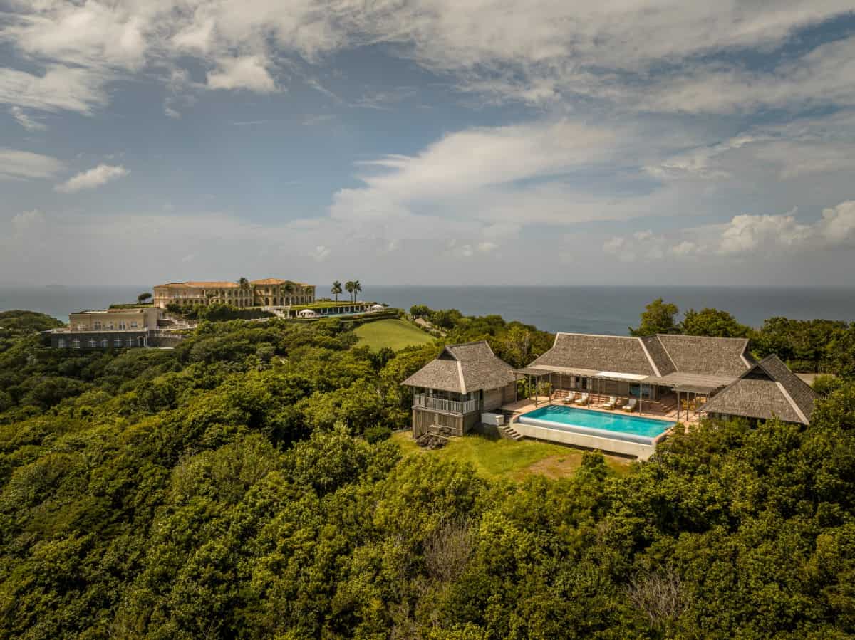 A separate building features a second pool surrounded by lush greenery.