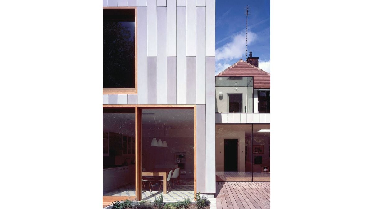 With a large addition covered in concrete panels, the plan reorients the house toward the backyard.