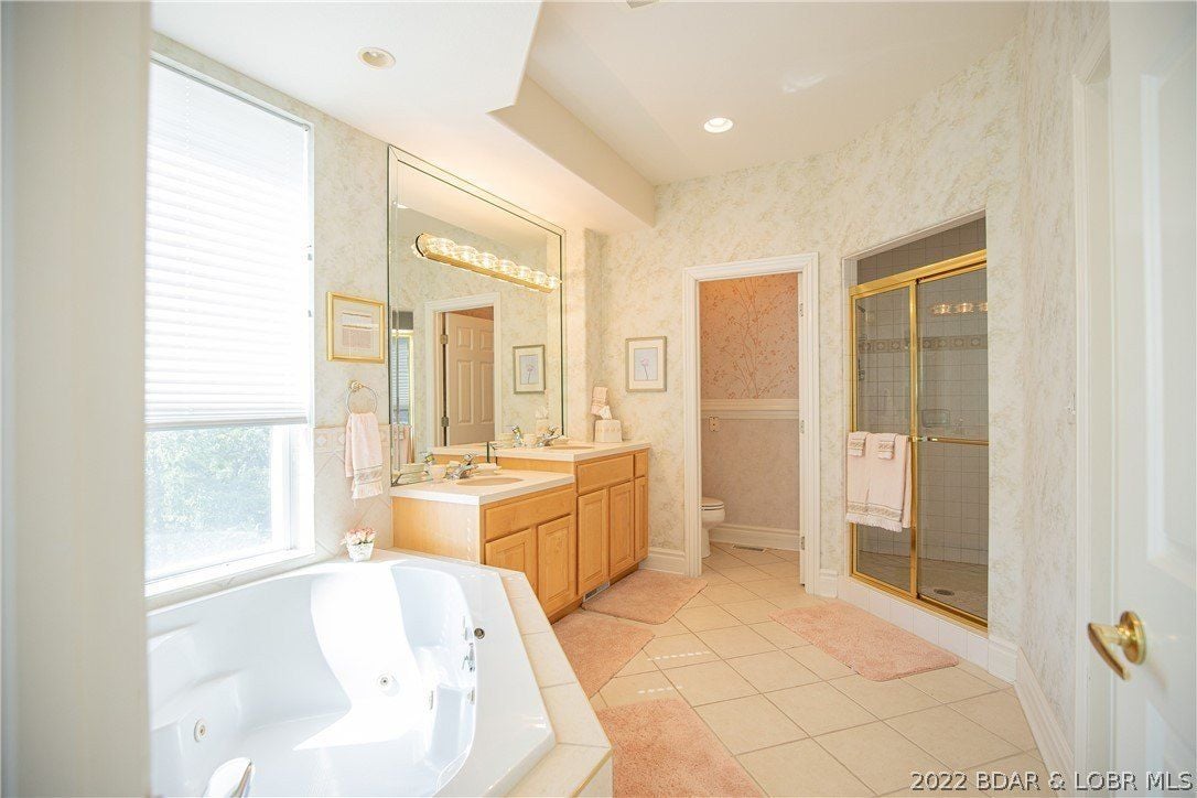 The bathroom features a hot tub spa and a shower cubicle with glass enclosure.