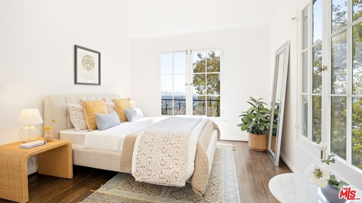 The bedroom features a double-sized bed, lampstand table, and a colonial-style window.