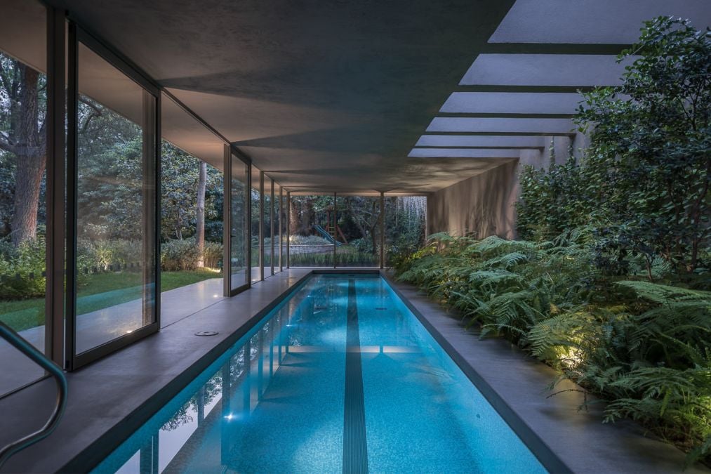 The indoor swimming pool is enveloped by lush foliage, creating a serene oasis amidst the greenery.