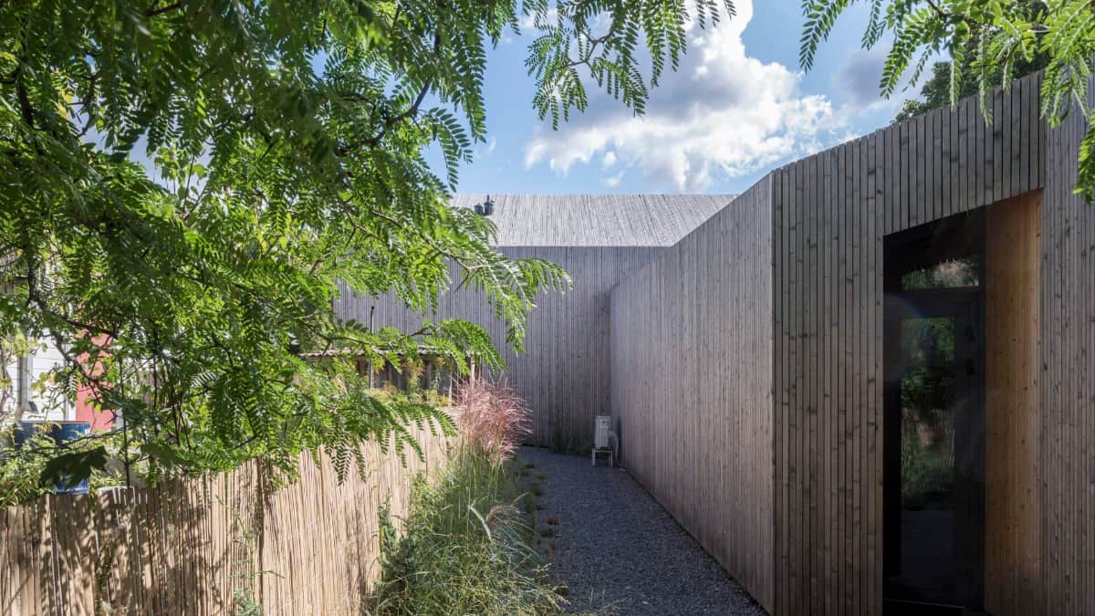 Wooden fences and tall plants enhance the home's privacy.