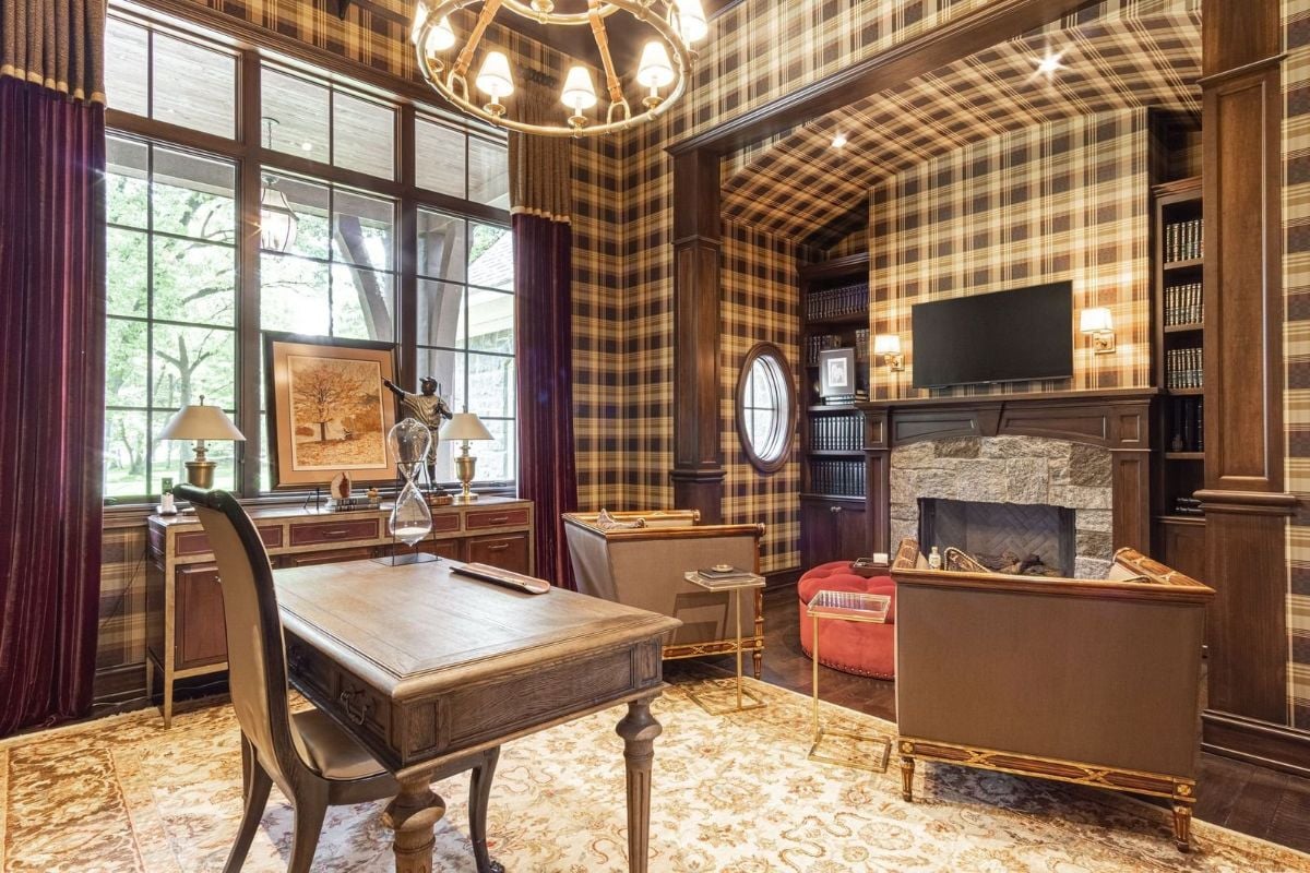The study features a wooden table and a fireplace that gives the room a cozy feel.
