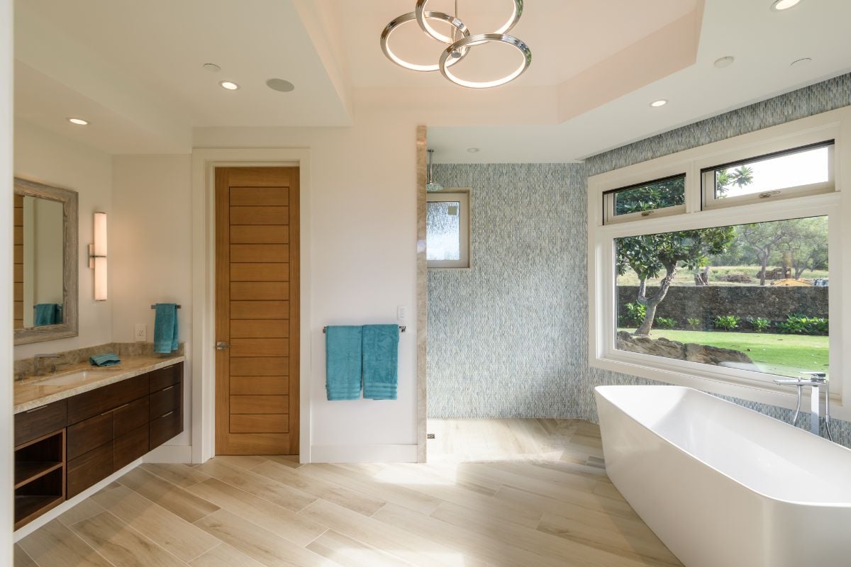 The bathroom features a wooden vanity with granite counterttop and a free-standing bathtub.