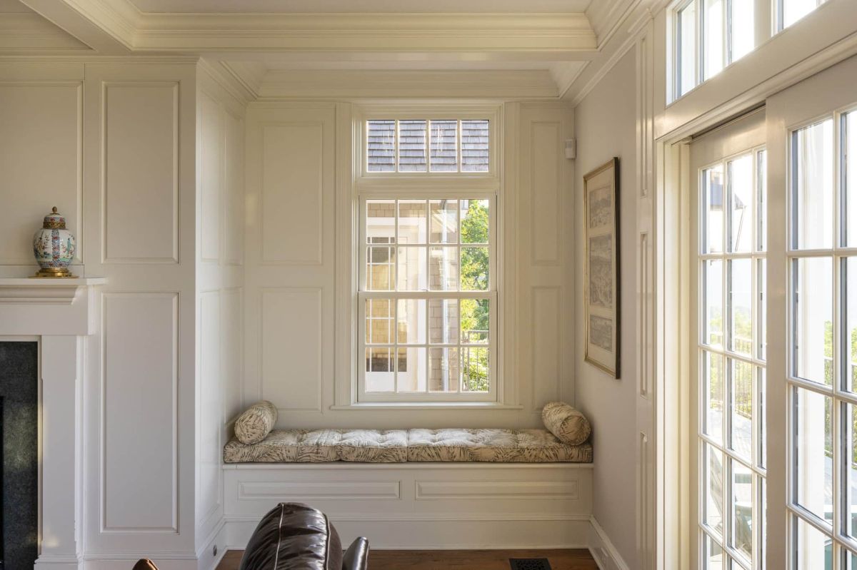 The bedroom features a window seat, and the glass walls showcase the view of the lakes.