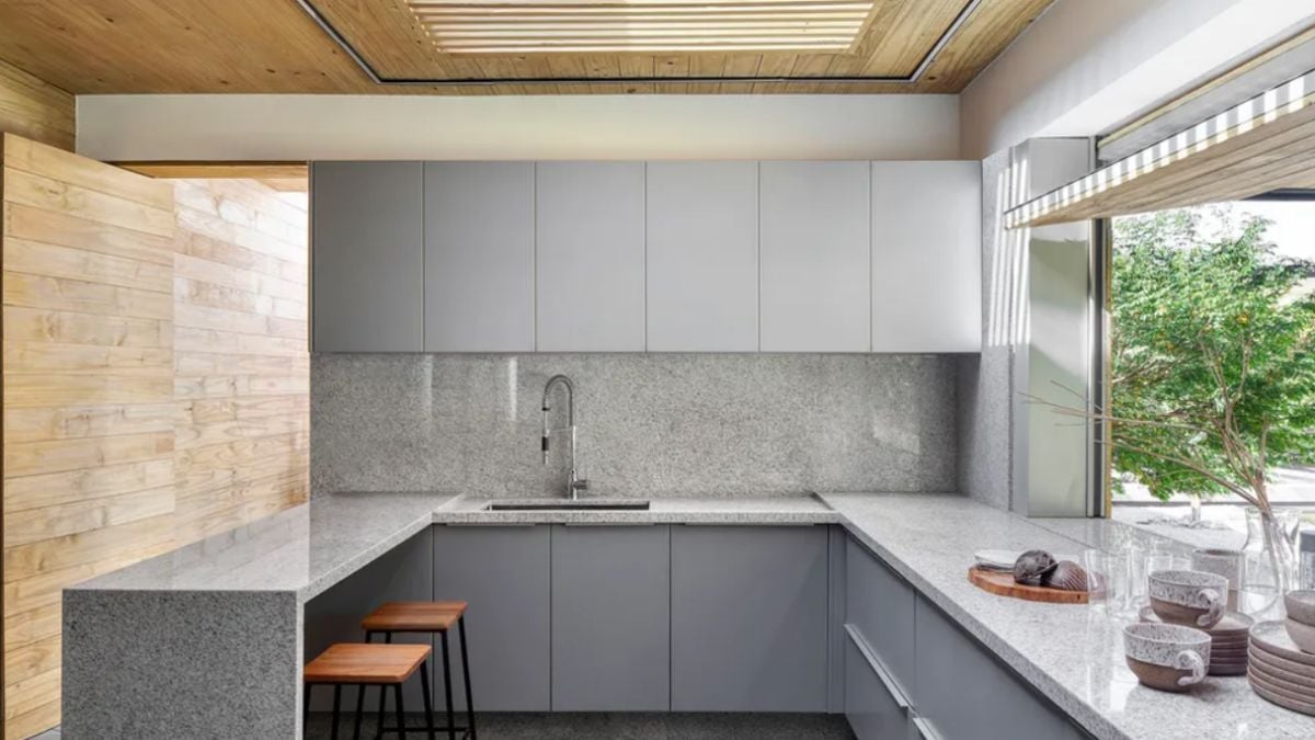 The home's kitchen has a glimpse of the outside and is painted a gray tone.