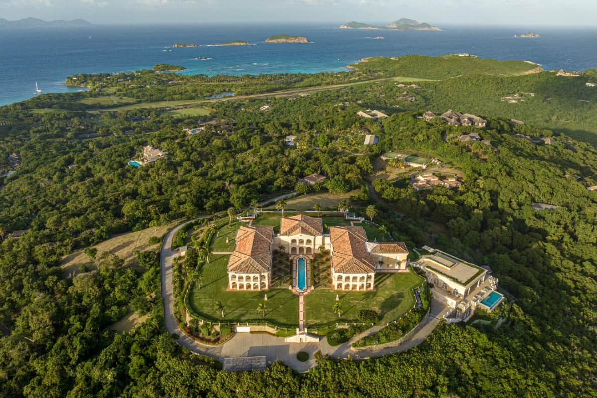 Aerial view of the Caribbean palatial estate showcasing its sprawling outdoor space embellished with pools and fountains.