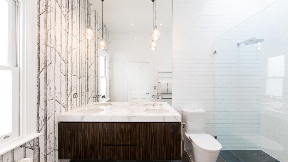 This photograph presents an interior design depiction of the bathroom, highlighting the two-station basin sink and shower area.