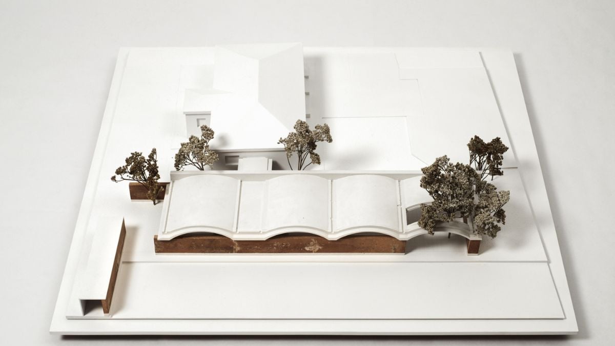 This miniature model of Casa IV is beautifully displayed against a white background, offering a detailed and scaled-down representation of the building's intricate architecture and design.