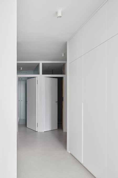 This is an interior shot of a pure white walk-in cabinet, featuring a clean and minimalist design.