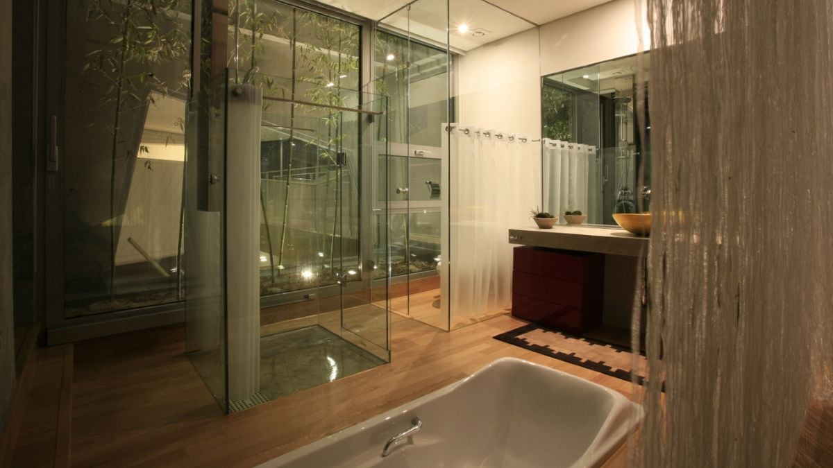 The bathroom is fully equipped, and the shower has glass doors.