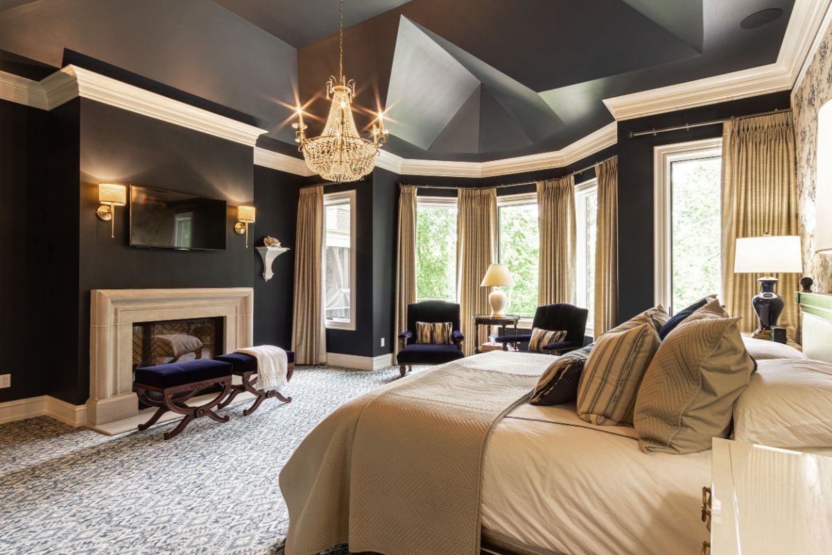 The en-suite features a bench and a fireplace that gives the room a cozy feel.