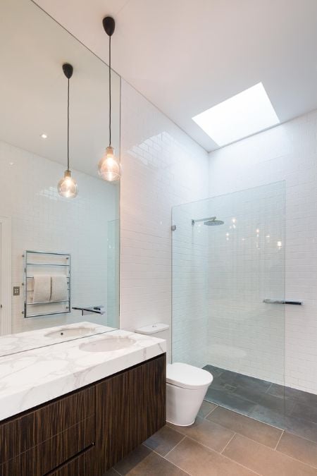 This is an interior photograph of a bathroom featuring a toilet, sink, and shower.