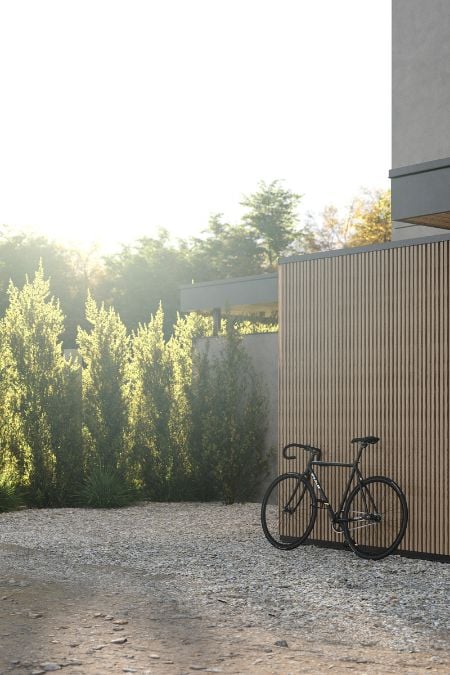 A bicycle is parked near the car park, which features grilled wood panels in its design.