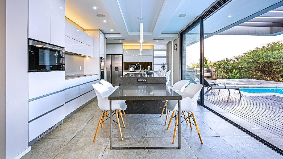 A grey island counter was painted to match the interior's tone and contrast with the kitchen's all-white cabinetry.