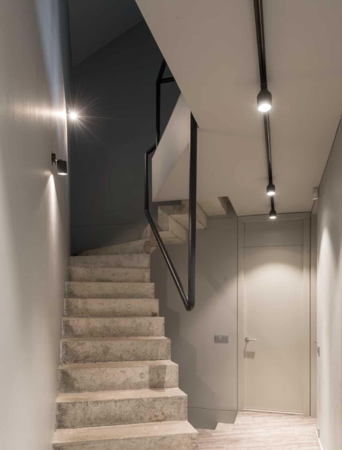 The concrete staircase with wrought iron railings adds industrial vibes to the house.