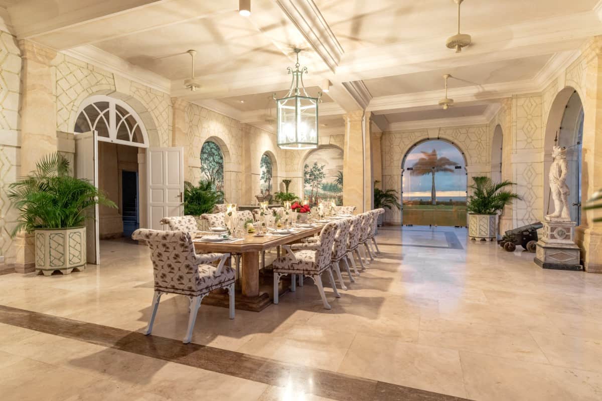 Formal dining room decorated with a coffered ceiling, a sculpture, and lovely tree murals.