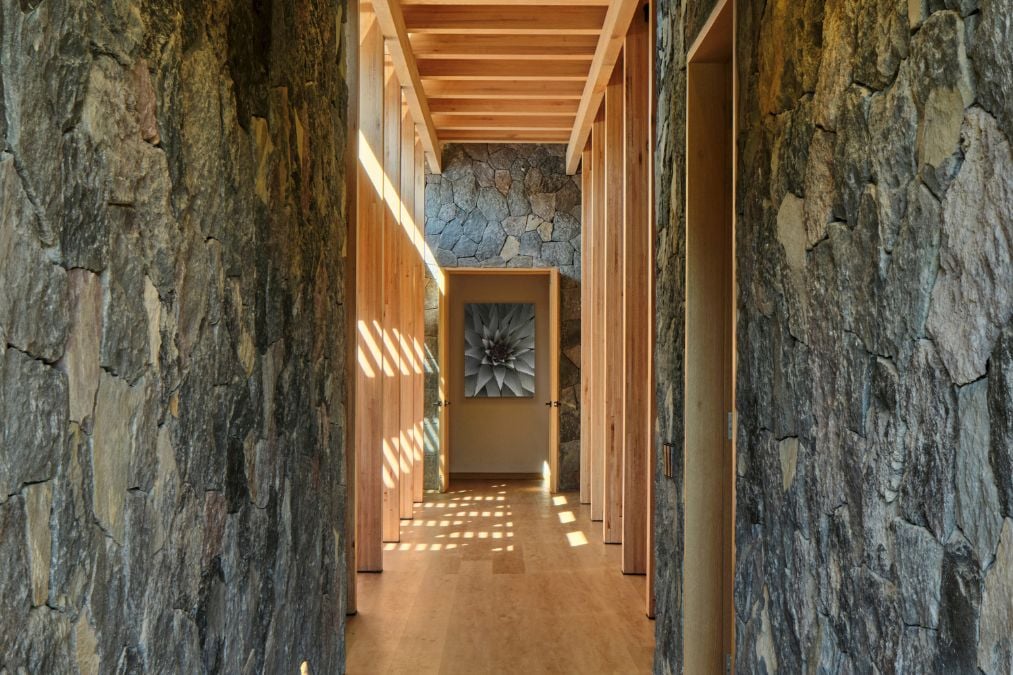 The long hallway is accentuated by both stone walls and a high wooden timber ceiling.