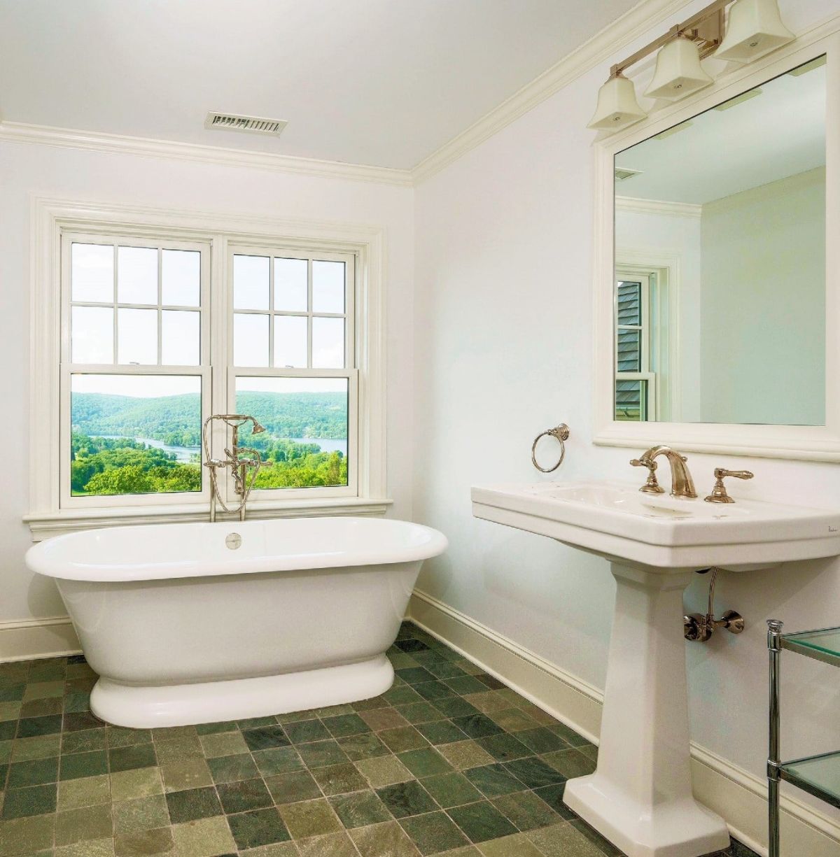 The bathroom features a freestanding bathtub, and the gold-plated fixtures give off a luxurious feel.