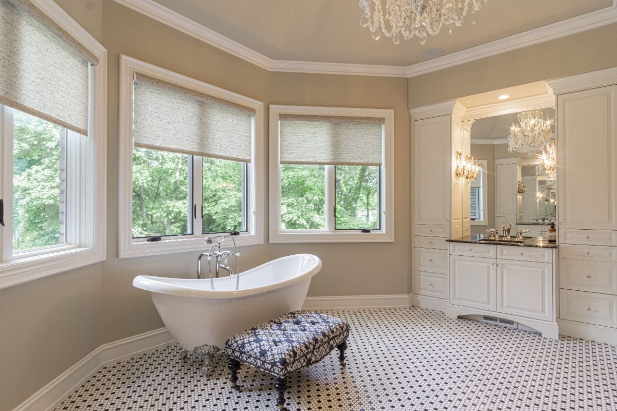 The en-suite bathroom features a freestanding bathtub and a vanity with luxurious lighting.