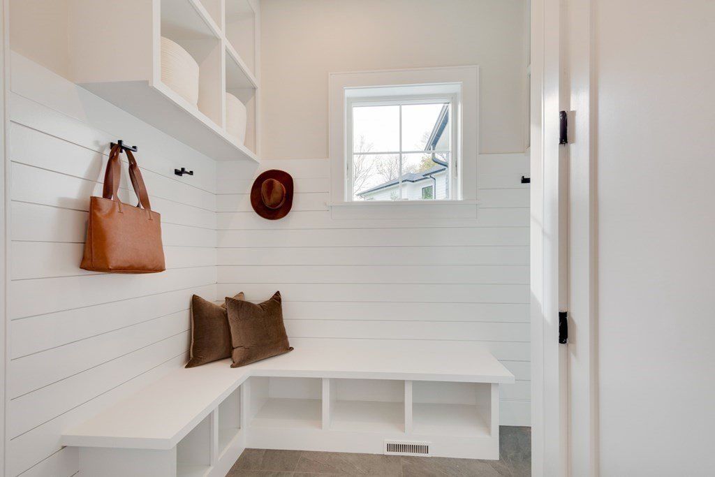The house features a mud room with a bench and wooden sidings.