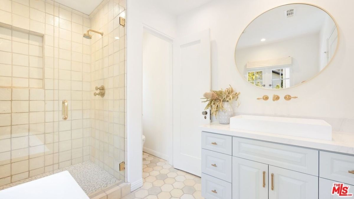 The bathroom features a vanity with a vessel sink and a glass-enclosed shower.