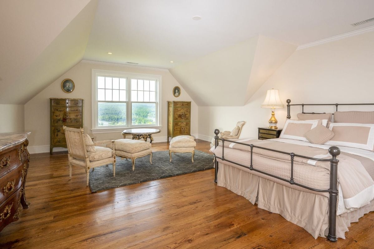 The bedroom features a queen-size bed, a lounge, and an area rug that gives off a cozy feel.