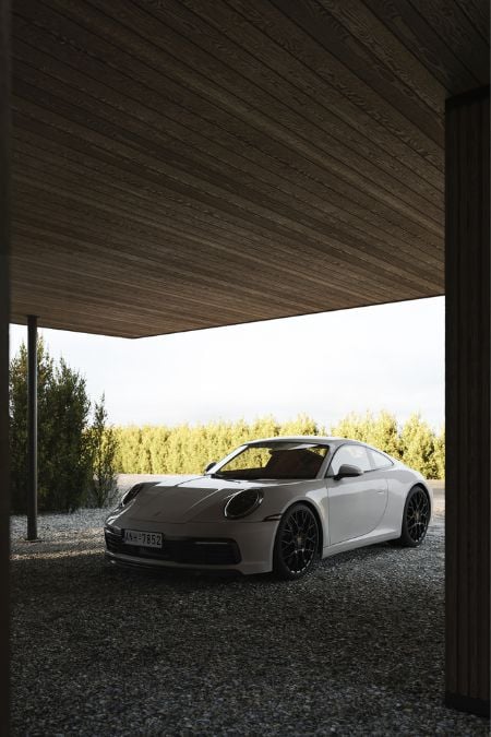 A white sports car is parked beneath a wooden planks ceiling.