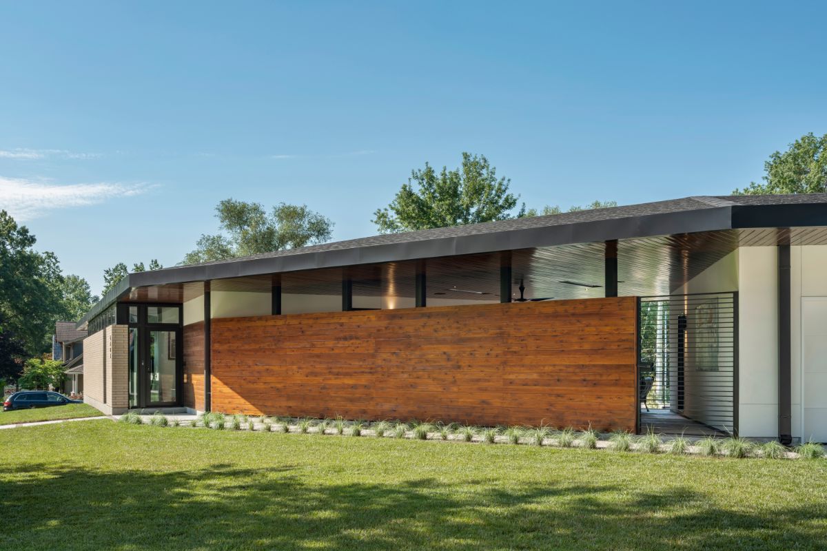 The low slung hipped roof creates an interstitial space that becomes a covered outdoor living room as the core of family life and gateway to the private back yard.
