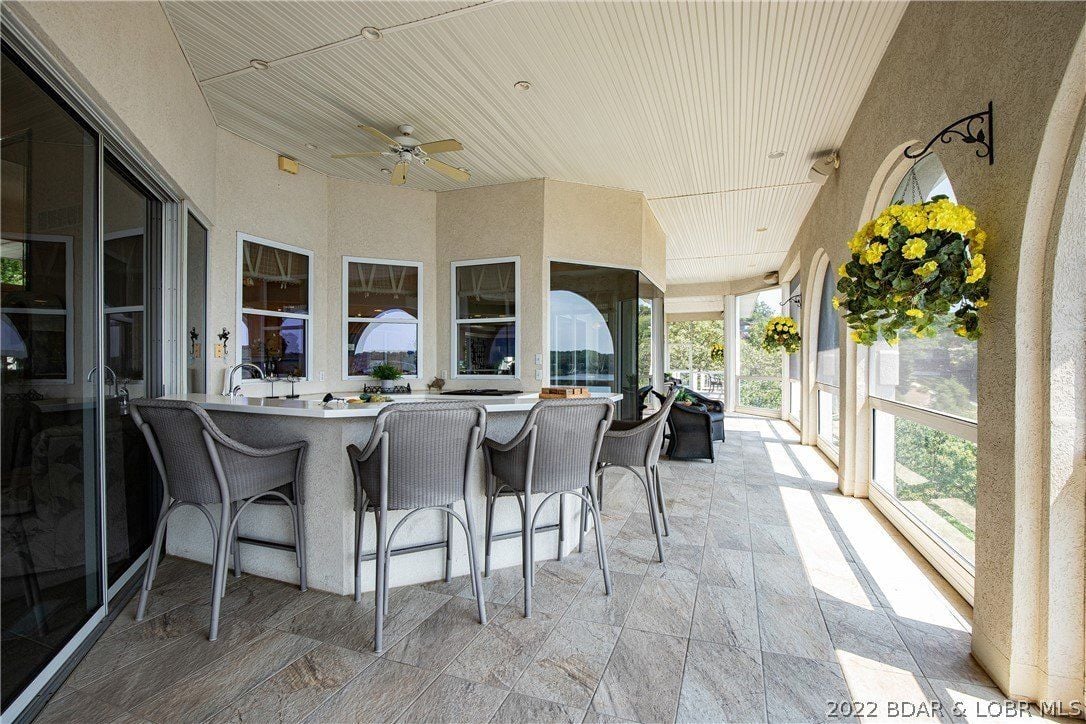 The home bar features a counter with a tile countertop, and the arch windows give off a classic feel.