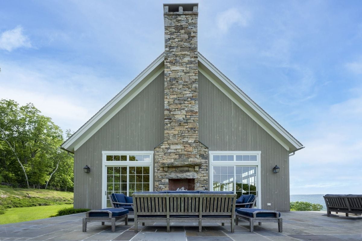 The house features an outdoor patio that blends well with the stone exterior, giving off a rustic feel.
