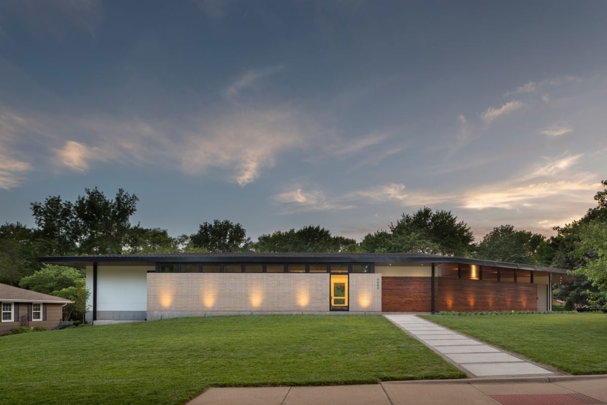 A low slung hipped roof with deep overhangs joins the masses.