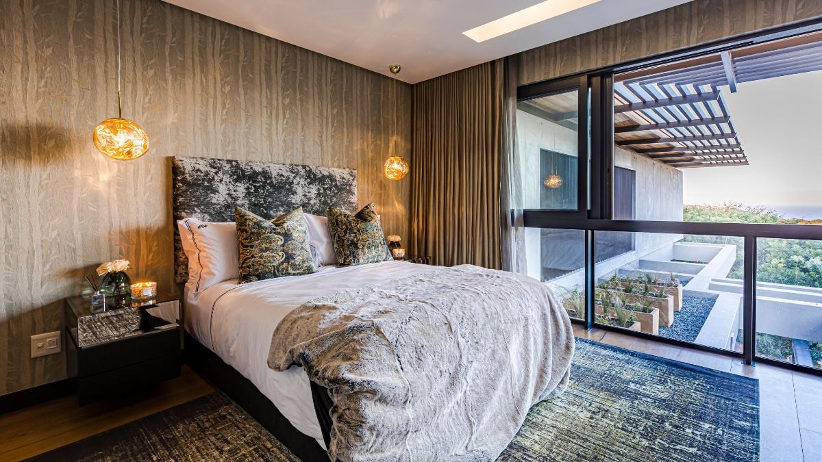 This master bedroom is beautifully-designed, with diverse hue wood and glass walls that brighten the space as well as distinctive lamps.