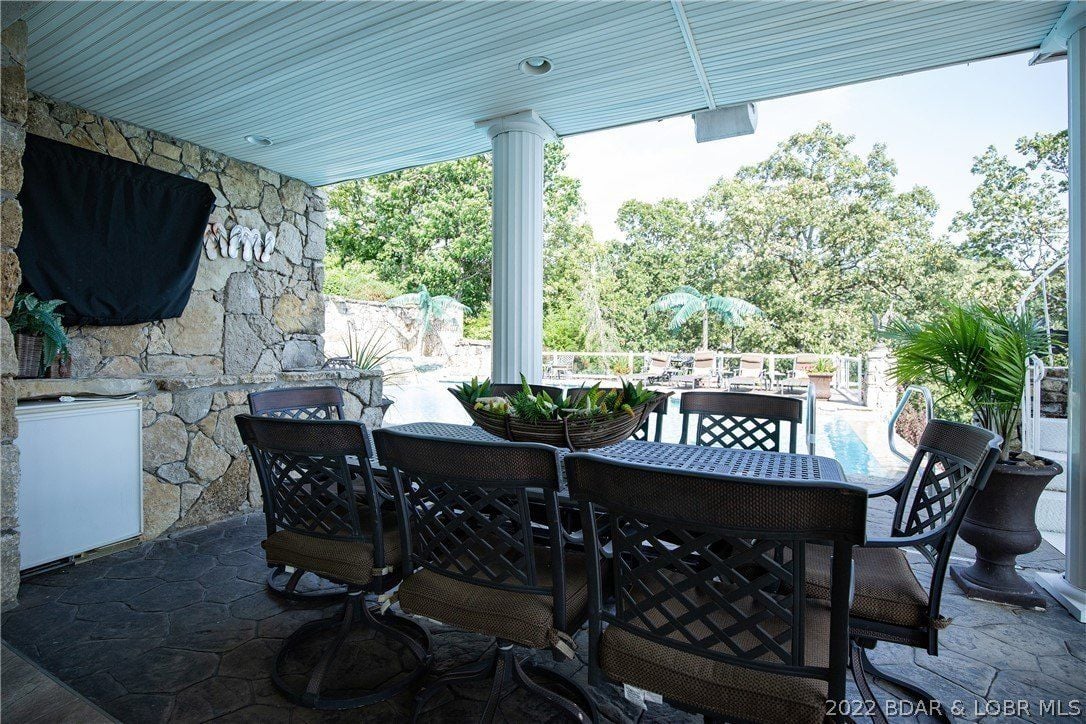 The house features an outdoor dining area near the pool.
