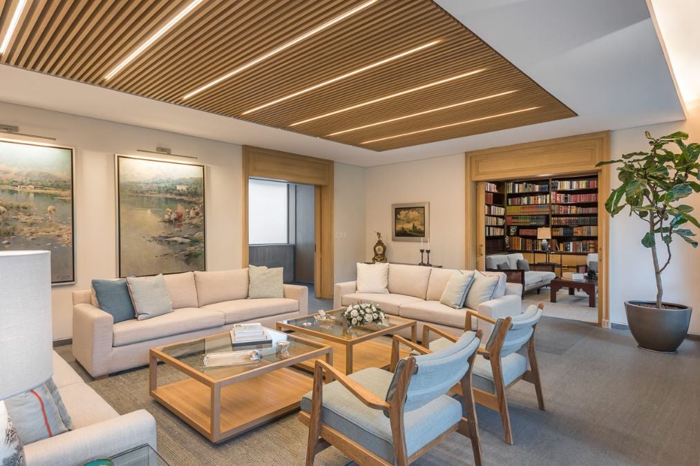 This inviting interior shot showcases the indoor living room of a residence, filled with tasteful furniture pieces and striking paintings adorning the walls.