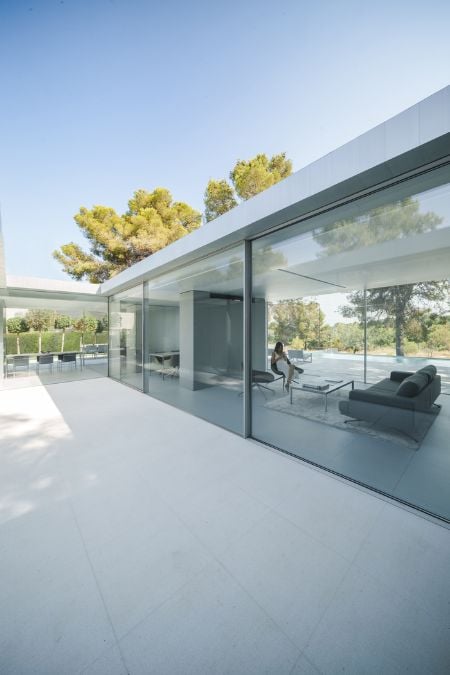 A photograph taken from the exterior, showcasing a room encircled by walls made of glass.