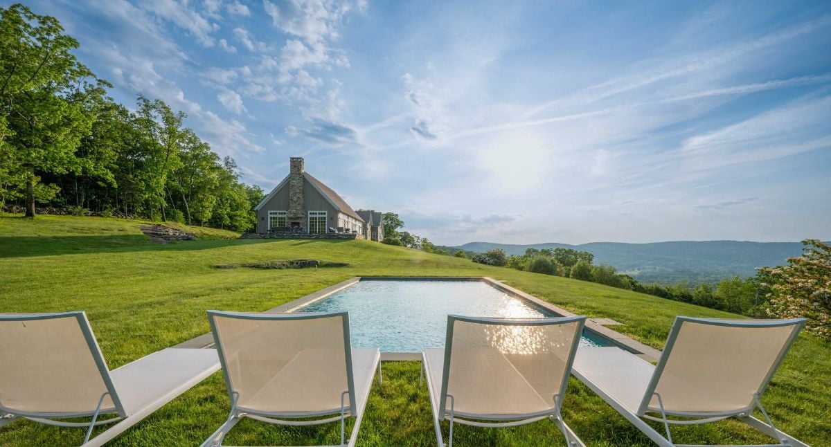 The swimming pool features a sun lounger and has a view of the mountains.