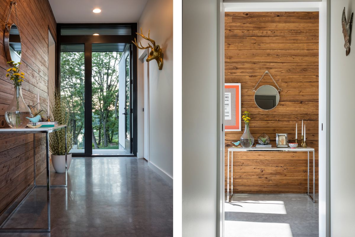 The foyer, which features a floor-to-ceiling glass door, a metal table with a small vanity, and animal statue home decor.