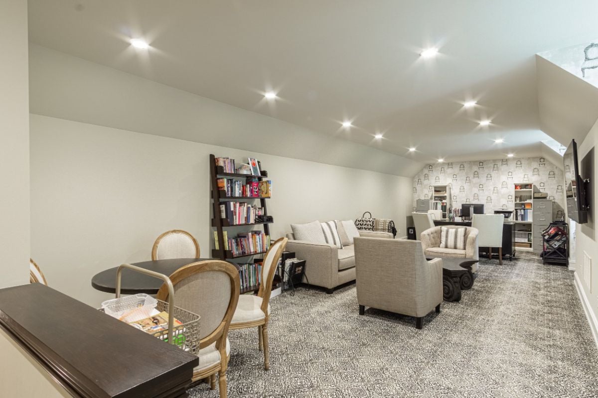 The room features a wall-to-wall carpet and a sofa that gives off a cozy feel.
