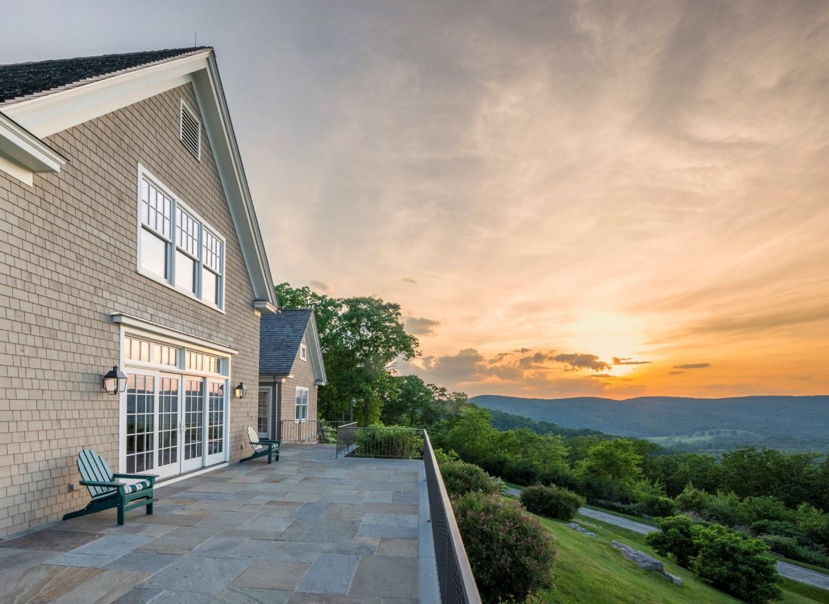 The house features an open balcony facing the street and a panoramic view of the mountains.