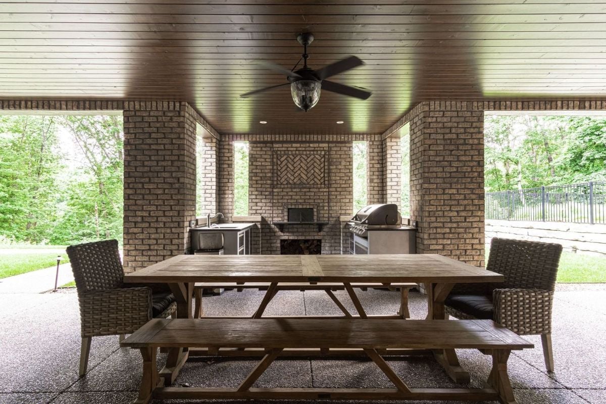 The house features an open dining and an outdoor kitchen with brick walls.