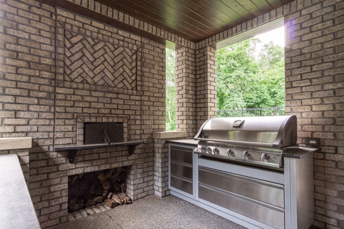 The kitchen features an oven and a gas range. The brick walls give off a rustic feel.