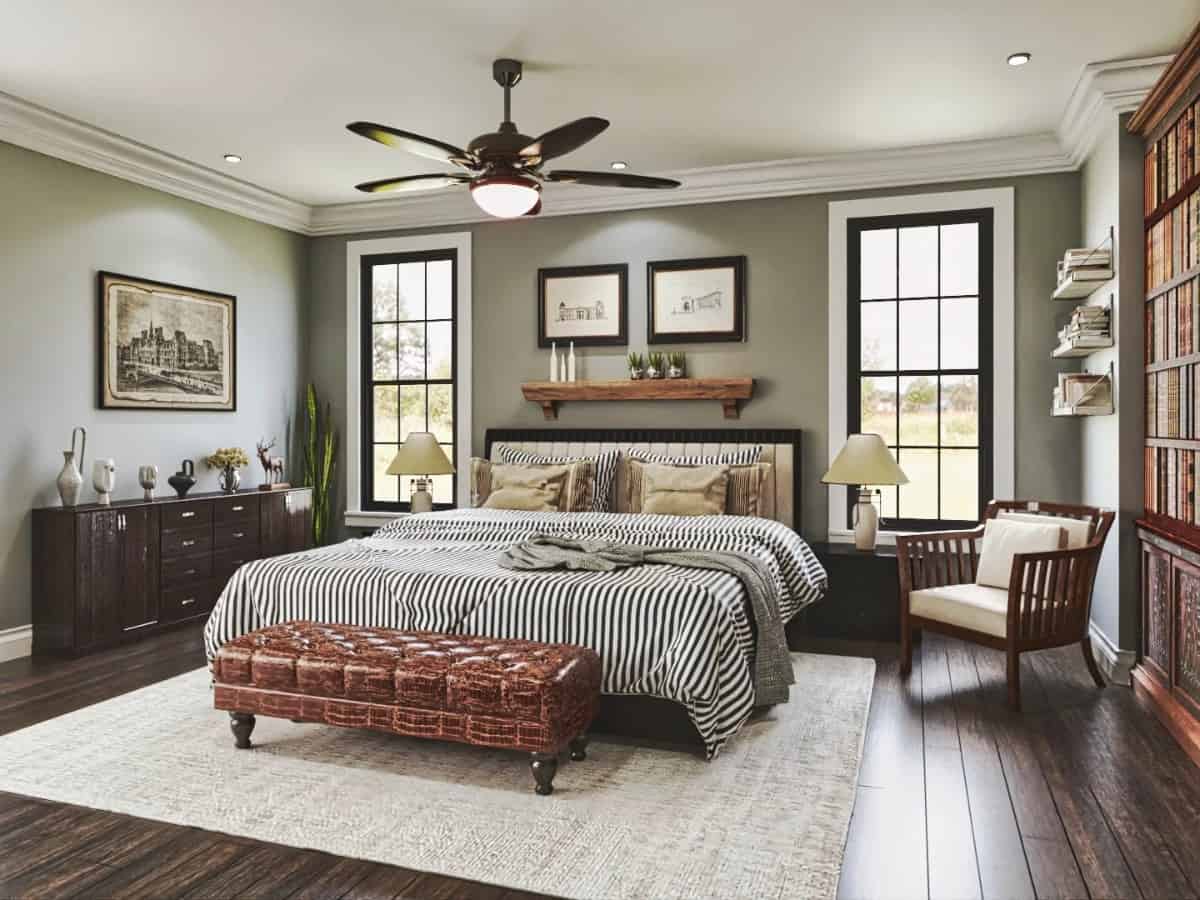 The primary bedroom features a built-in bookcase and a dark wood bed complemented with a leather tufted bench and a cushioned armchair.