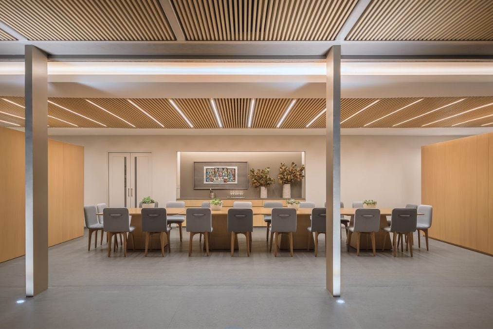A dining area featuring an elongated table and accompanying chairs, typically intended for a social gathering.