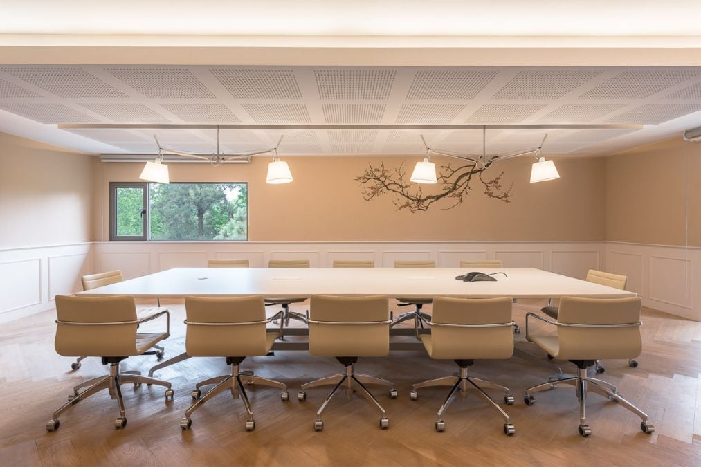 A conference room, featuring a sizable table and accompanying chairs to accommodate a group of individuals.